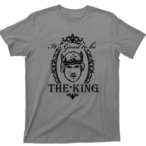 May include: A grey t-shirt with a black graphic of a man wearing a crown and the text "It's Good to be The King".
