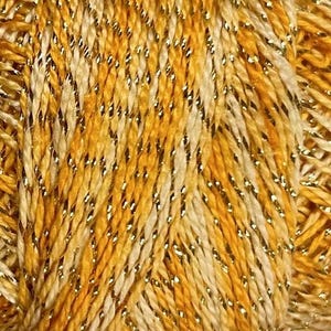 May include: Close-up of a skein of yarn with a textured appearance. The yarn is a blend of yellow, cream, and gold metallic threads. The threads are tightly twisted together, creating a visually interesting and tactile surface. Ideal for knitting and crochet projects.
