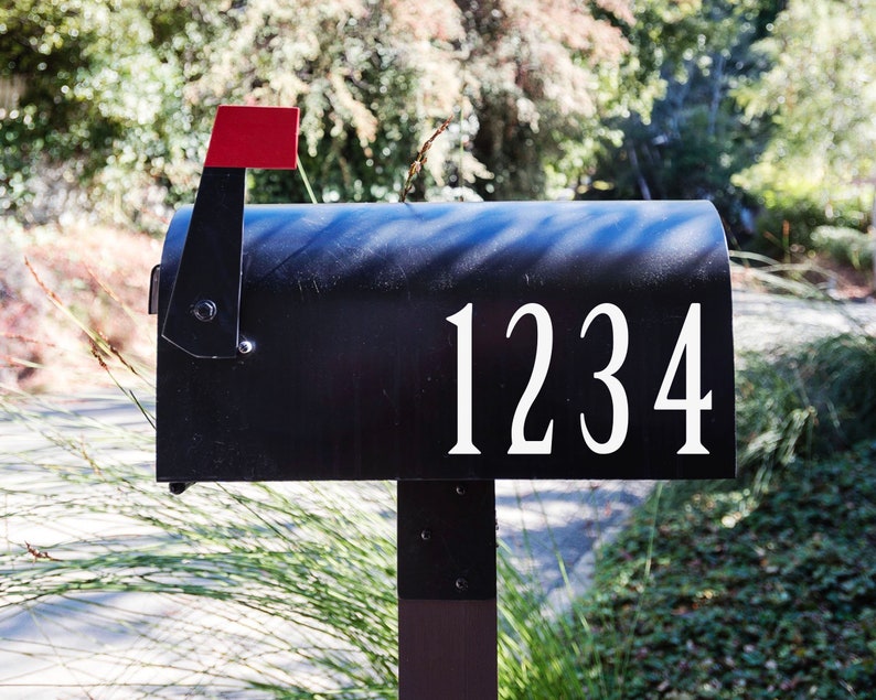 May include: A black mailbox with a red flag and the number 1234 in white lettering.