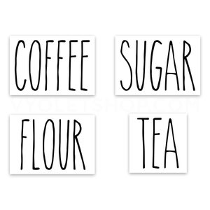 May include: Four white labels with black handwritten text. The labels read "COFFEE", "SUGAR", "FLOUR", and "TEA".