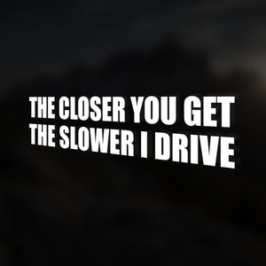 May include: White text on a black background reads "The closer you get the slower I drive".