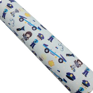 May include: Blue and white patterned fabric with a repeating design of police officers, police cars, handcuffs, and stars. The fabric has a textured surface.