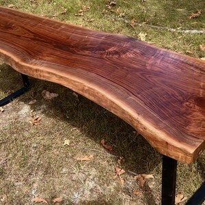 Handcrafted black walnut live edge console table with modern black industrial U-legs, showcasing rich wood grain and organic edge detail, rustic farmhouse style.