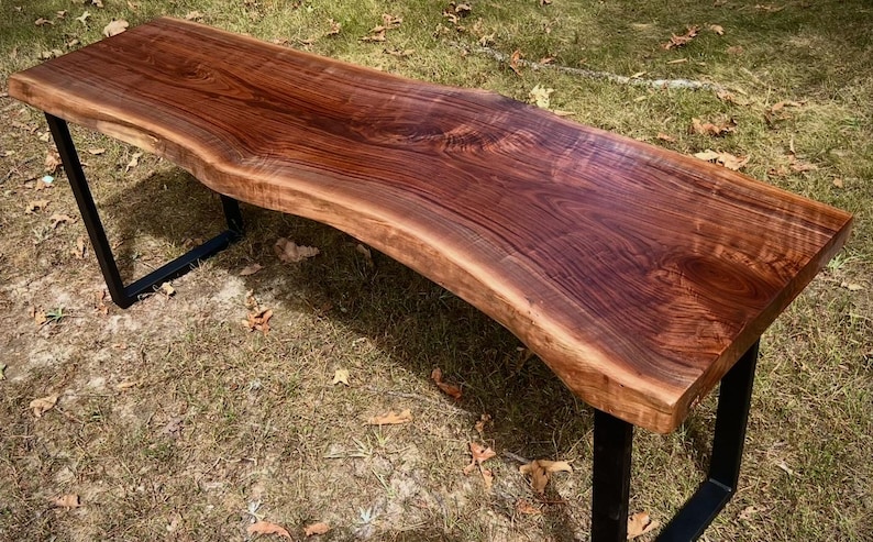Handcrafted black walnut live edge console table with modern black industrial U-legs, showcasing rich wood grain and organic edge detail, rustic farmhouse style.