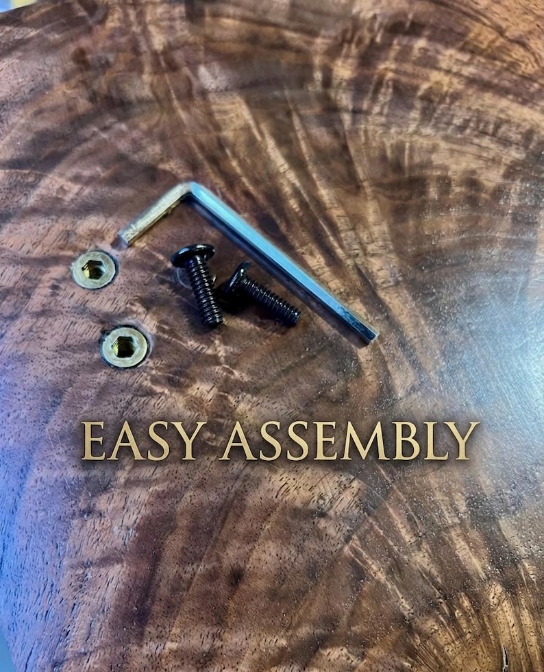 May include: Close-up of a wooden surface with the text "EASY ASSEMBLY" in gold lettering. Two black screws, a silver Allen key, and two gold-coloured screw holes are visible.