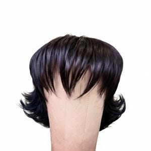 May include: A dark brown wig with a short, layered style. The wig features a blunt fringe and wavy sides, styled on a mannequin head. The hair has a natural shine and is set against a white background.