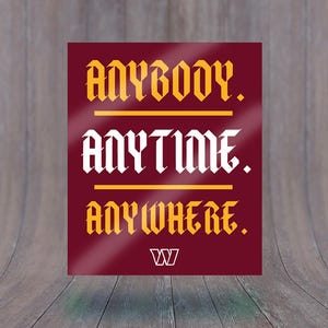 May include: A maroon square with the words "ANYBODY. ANYTIME. ANYWHERE." in white and gold gothic font. The Washington "W" logo is at the bottom. The background is a wooden surface.