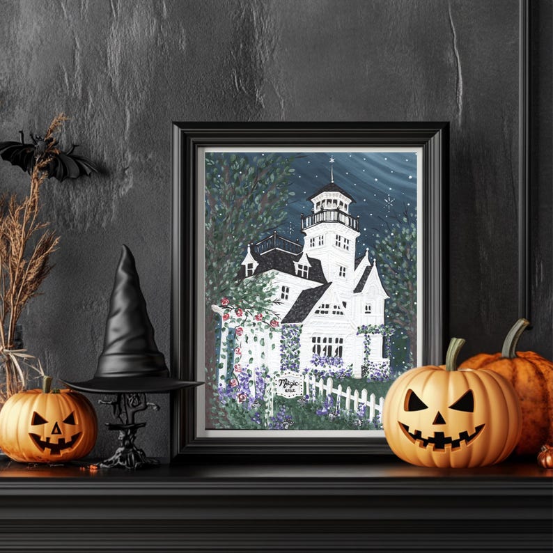 May include: A framed print of a white house with a lighthouse tower, surrounded by trees and flowers, sits on a black mantel. A carved jack-o'-lantern, a black witch hat, and a bat decoration complete the Halloween theme.