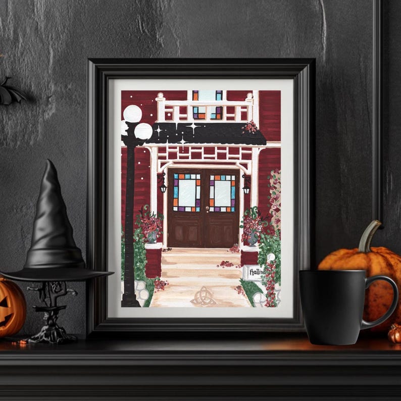 May include: A framed print of a red building with a white porch and stained glass windows. A black witch hat, a small pumpkin, and a black mug are on the mantel. The print has the word "Hollins" on it.