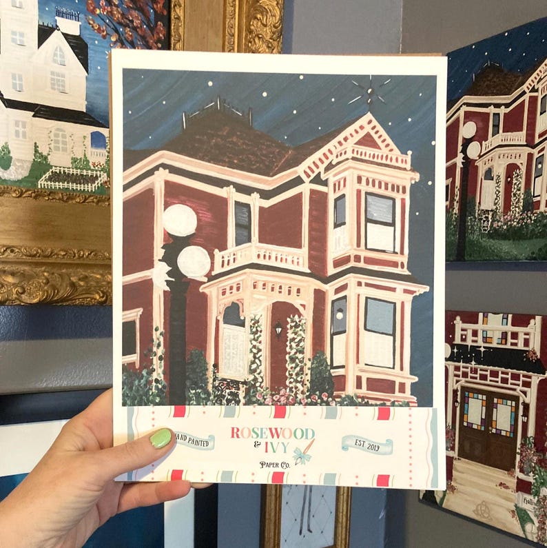 Puede incluir: Una impresi&oacute;n pintada a mano de una casa victoriana en tonos burdeos, crema y marr&oacute;n, sobre un cielo nocturno azul oscuro con estrellas. La impresi&oacute;n incluye una farola y el texto "Rosewood & Ivy Paper Co. EST 2019".