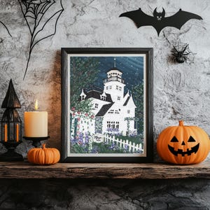 May include: A framed print of a white house with a tower, surrounded by a white picket fence and flowers. A lit candle, a small pumpkin, and a carved jack-o'-lantern pumpkin sit on a wooden shelf. Halloween decor includes a bat and spider.