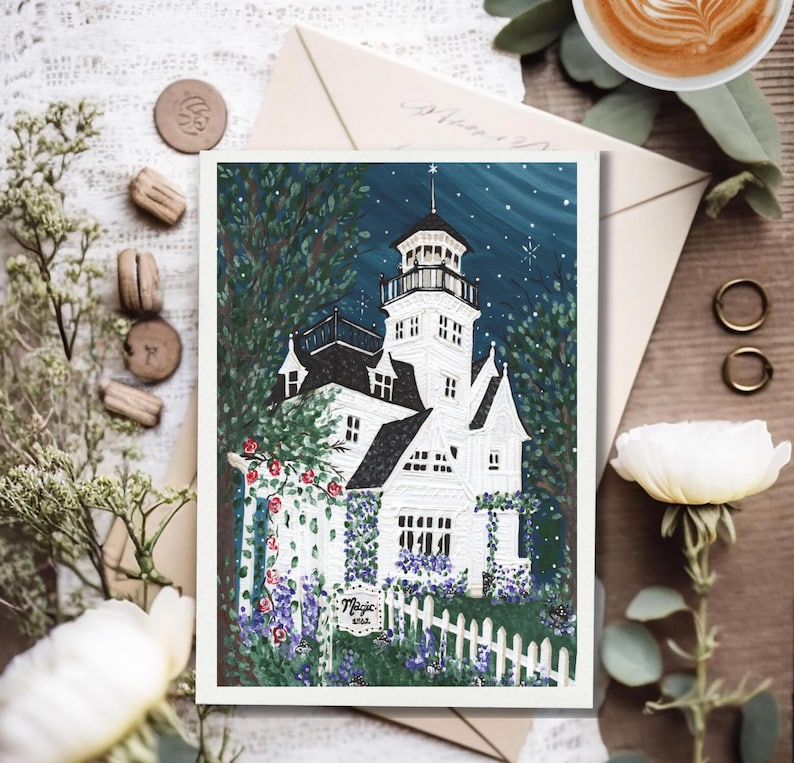 May include: A white illustration of a Victorian house with a tower, surrounded by a white picket fence and lush greenery. The night sky is dark blue with stars. The word "Magic" is visible on a small sign.