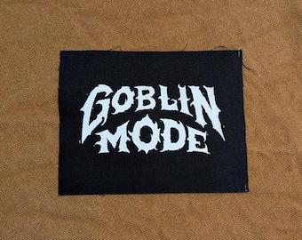 May include: Black fabric patch with white text that reads "GOBLIN MODE" in a stylized font.