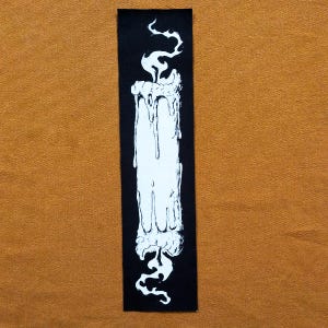 Könnte beinhalten: Ein schwarzer Patch mit einer weißen Illustration einer tropfenden Kerze mit einer Flamme. Die Kerze ist von einem schwarzen Hintergrund umgeben.