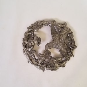 hummingbird feeding in circular metal wall art sculpture