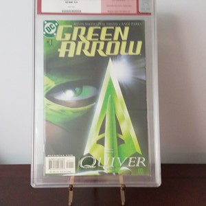 May include: A Green Arrow comic book, issue #1, in a clear plastic protective case. The cover features a close-up of Green Arrow's eye and a green arrow. The title "Green Arrow" is in large, bold letters. The comic book is graded CGC 9.0.