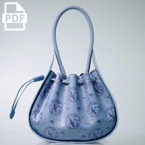 May include: A light blue drawstring handbag with a circular crane pattern. The bag has a rounded shape with a matching handle and trim. The PDF icon is in the upper left corner.