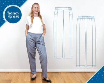 Puede incluir: Una mujer con una camiseta blanca y pantalones grises se encuentra de pie frente a una pared blanca. Dos dibujos lineales de pantalones están en la pared. Los pantalones de la izquierda tienen un bolsillo en la parte delantera. Los pantalones de la derecha tienen una cintura.