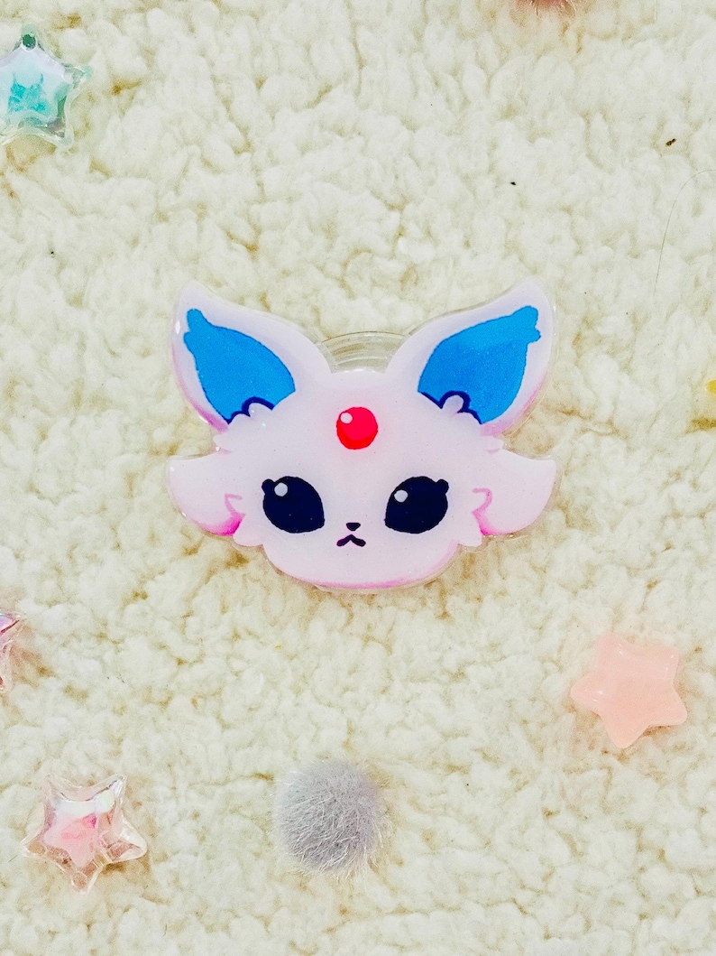 Puede incluir: Un personaje de dibujos animados rosa y azul con ojos grandes y una gema roja en la frente. El personaje est&aacute; hecho de pl&aacute;stico y tiene un acabado brillante.