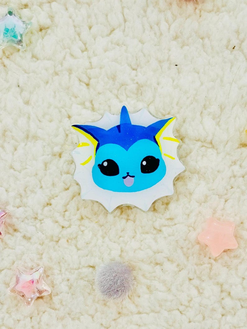 Puede incluir: Un personaje de dibujos animados azul y amarillo con fondo blanco. El personaje tiene ojos grandes, una boca peque&ntilde;a y una aleta en la cabeza.