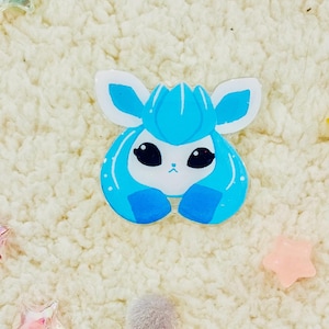 Puede incluir: Un personaje de dibujos animados azul y blanco con ojos grandes y una pajarita. El personaje es un personaje popular de anime y videojuegos.