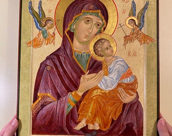 Könnte beinhalten: Eine Ikone, die die Jungfrau Maria mit dem Christuskind zeigt, mit zwei Engeln auf beiden Seiten. Die Figuren sind in satten Farben gemalt, darunter Lila, Gold und Blau, mit einem goldenen Heiligenschein um ihre Köpfe. Die Ikone ist in dunklem Holz gerahmt.
