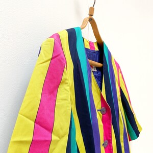 May include: A striped blazer with yellow, pink, blue, purple and green stripes. The blazer has a button closure and short sleeves.