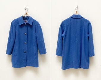 May include: A blue wool coat with a button-up front and long sleeves. The coat has a classic design and is perfect for layering in colder weather.