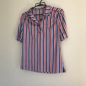 May include: A striped short-sleeved shirt with a collar and button closure. The shirt is white with red, blue, and light blue stripes.