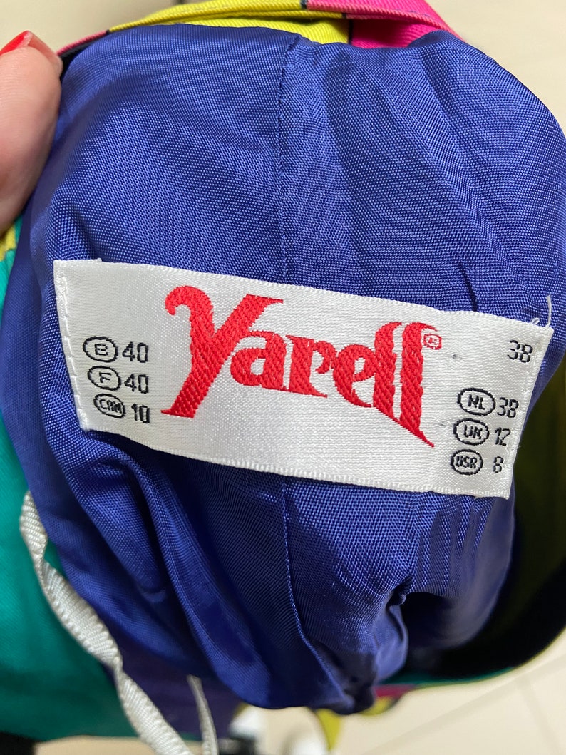 May include: A white tag with the word "Yarell" in red lettering. The tag has size information in black text: B 40, F 40, CM 10, NL 38, UK 12, US 8.