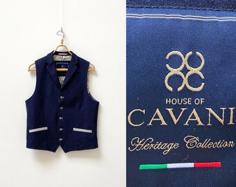 May include: A navy blue waistcoat with a button closure and two pockets. The waistcoat has a white trim on the pockets and a patterned lining. The label reads "House of Cavani Heritage Collection".