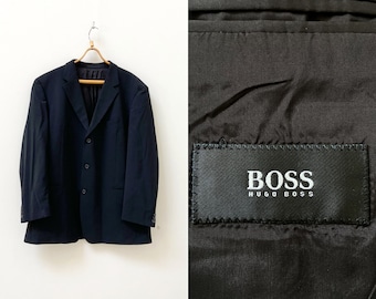 May include: A black blazer with a three-button closure and a label that reads "BOSS HUGO BOSS".