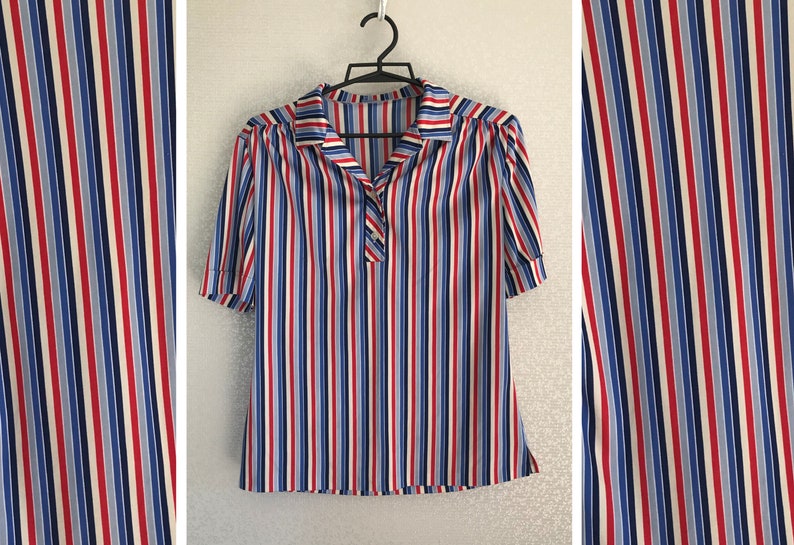 May include: A striped short-sleeved blouse with a collared neckline. The blouse has vertical stripes in red, blue, white, and light blue.