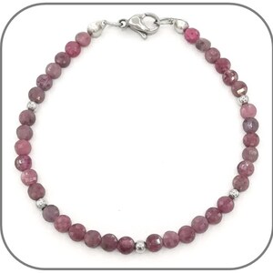 Può includere: Un braccialetto di pietre preziose rosa e viola con perline d'argento e una chiusura argentata.