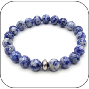 May include: A blue and white gemstone bracelet with a silver bead accent. The bracelet is made of round beads and is approximately 8 inches in length.
