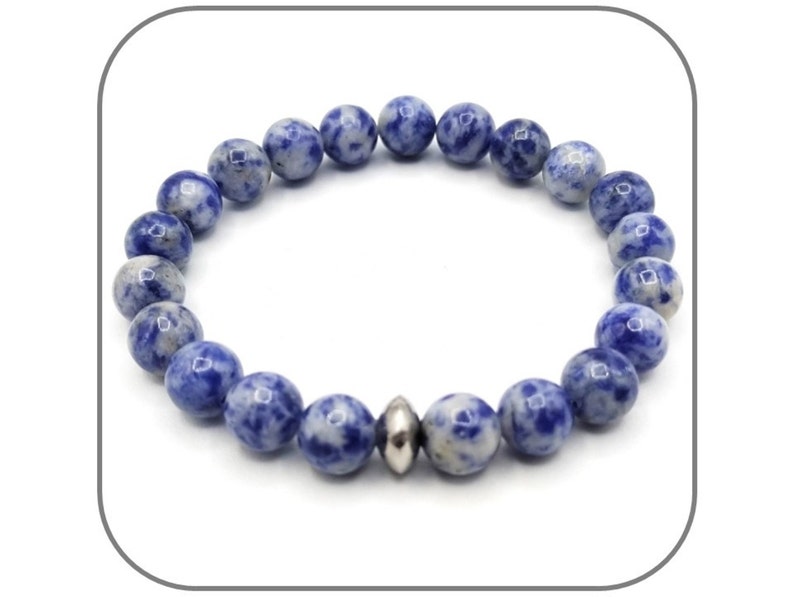 May include: A blue and white gemstone bracelet with a silver bead accent. The bracelet is made of round beads and is approximately 8 inches in length.