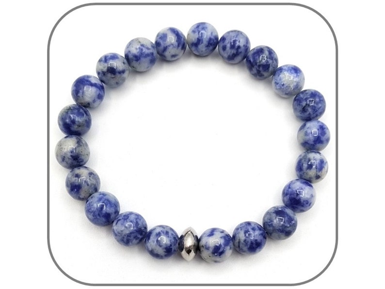 May include: A blue and white gemstone bracelet with a silver bead accent. The bracelet is made of round beads and is approximately 7 inches in length.