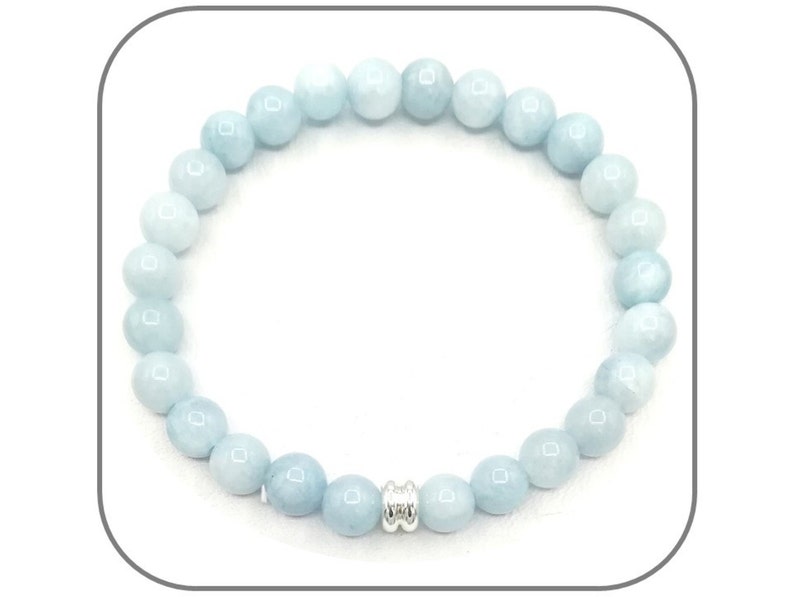 May include: A light blue gemstone bracelet with a silver bead accent. The bracelet is made of round beads and is approximately 7 inches in length.
