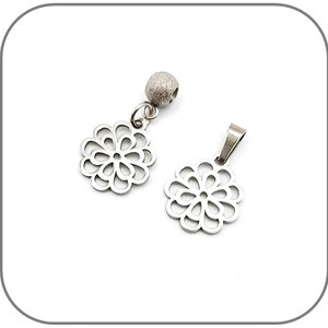 Peut inclure: Deux pendentifs en métal argenté en forme de fleur avec des découpes complexes. Un pendentif est attaché à une perle argentée.