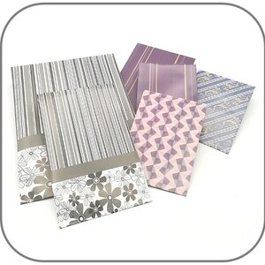 May include: Five decorative envelopes with different patterns. The envelopes are in shades of purple, pink, and gray. The patterns include stripes, geometric shapes, and floral designs.
