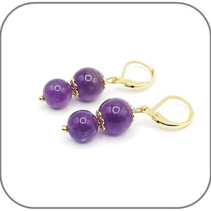Può includere: Un paio di orecchini d'oro con due perle di ametista su ogni orecchino.