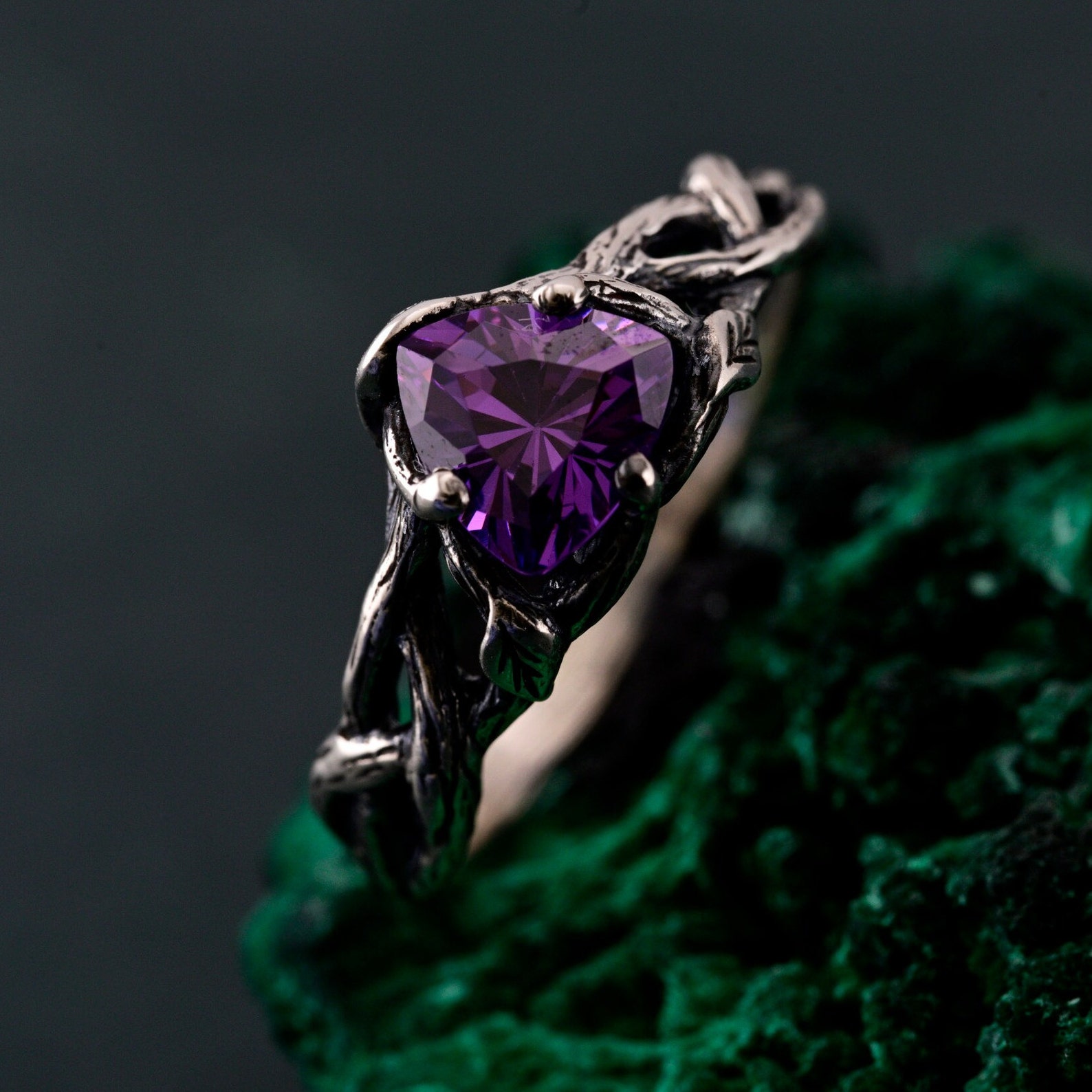 Celtic-inspired amethyst ring with oxidized silver twig band on green stone background