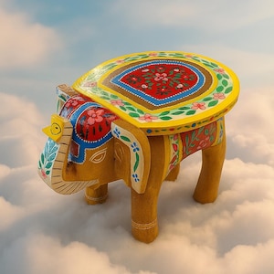 May include: A hand-painted wooden elephant stool with a yellow seat featuring a red floral design. The elephant is painted in shades of yellow, red, blue, and white. The stool is a decorative piece of furniture.