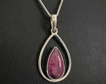 May include: A silver chain necklace with a teardrop-shaped pendant featuring a purple gemstone.