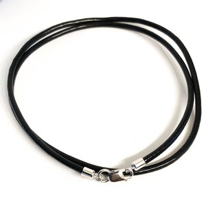 May include: A black leather cord necklace with silver clasps.