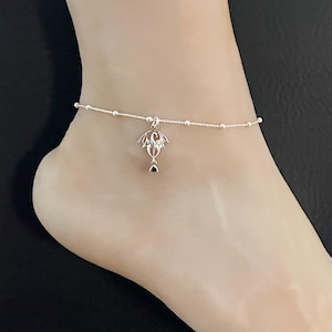 May include: Silver anklet with a delicate chain and a small dragon charm.