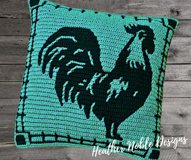 May include: A square, turquoise crochet pillow featuring a black rooster silhouette. The pillow has a black border with a fence design and the text "Heather Noble Designs" in the bottom right corner.