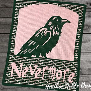 May include: A handmade crochet blanket featuring a dark green raven silhouette against a pink background. The blanket has a brick-like border and the words "Nevermore" in pink. The design is by Heather Noble Designs.