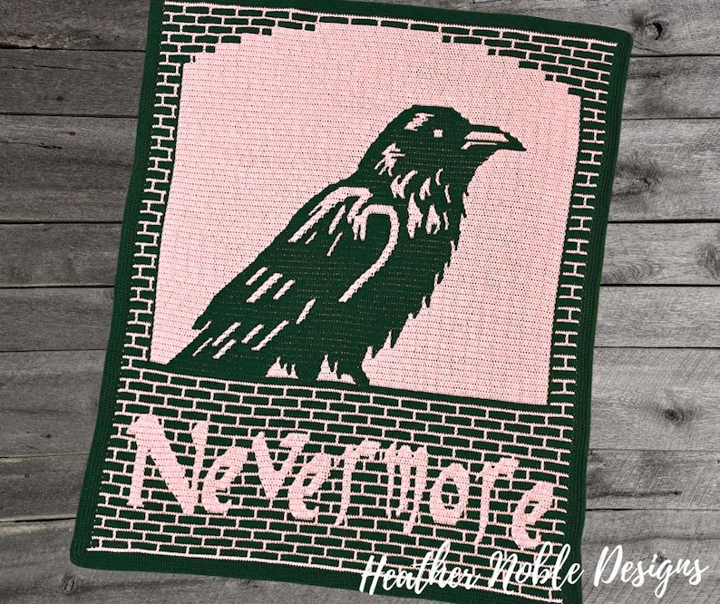 May include: A handmade crochet blanket featuring a dark green raven silhouette against a pink background. The blanket has a brick-like border and the words "Nevermore" in pink. The design is by Heather Noble Designs.