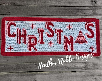 May include: A rectangular crochet wall hanging featuring the word CHRISTMAS in red block letters on a light blue background. The design includes small red star motifs and a red triangular tree shape replacing the letter A.